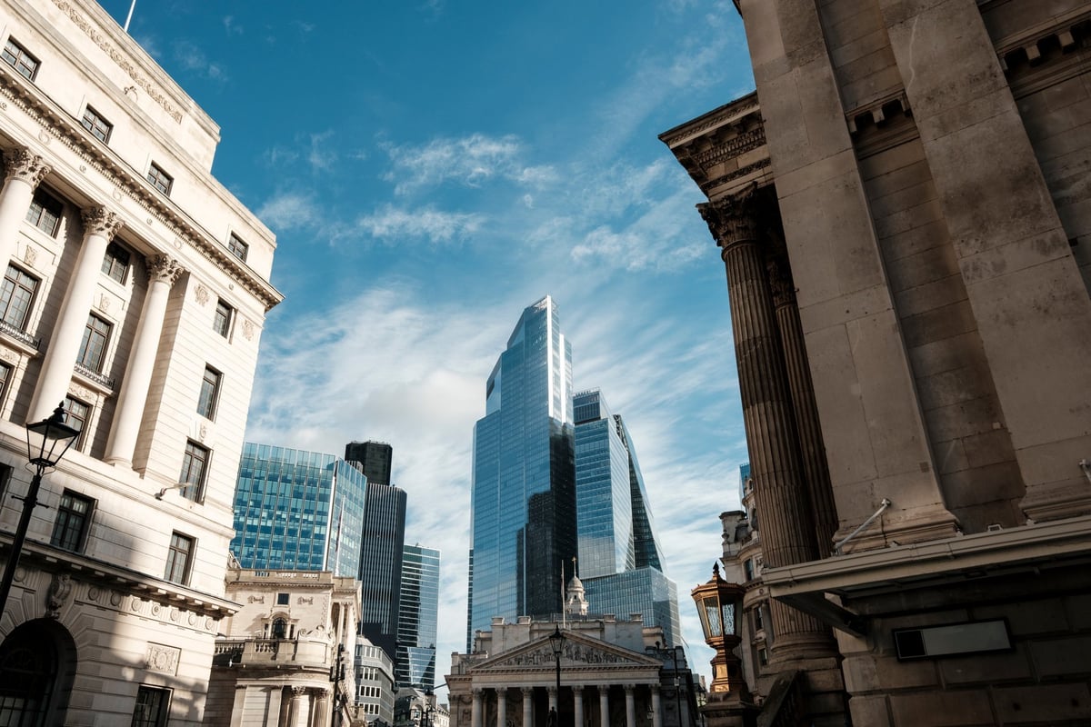 Griffith NSW cityscape showing historic stone buildings framing modern glass skyscrapers in the financial district under a bright blue sky, contrasting old and new urban growth